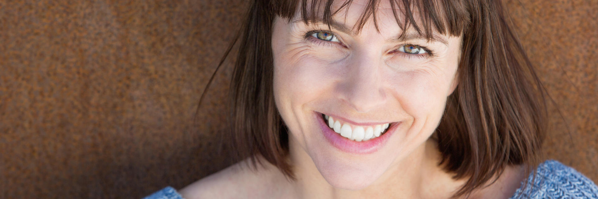 Happy brunette middle-aged woman showing nice teeth in her smile.