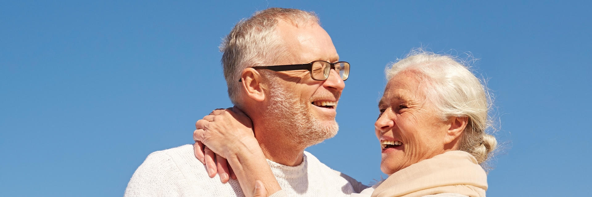 Happy senior couple with perfect smiles relaxing outdoors on a sunny day.