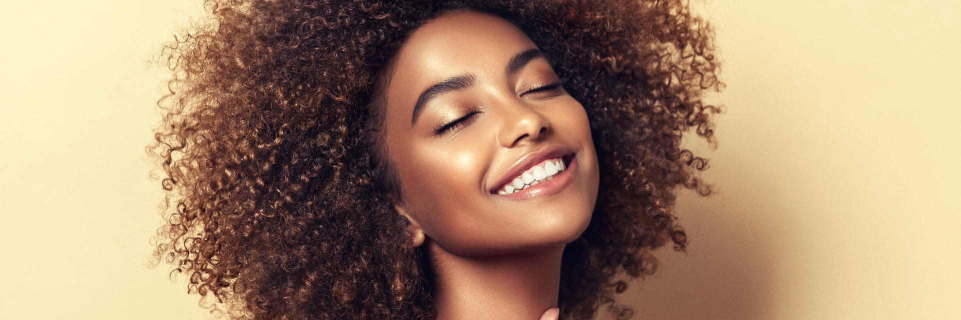 Happy young Afro-American woman showing her beautiful teeth in smile.