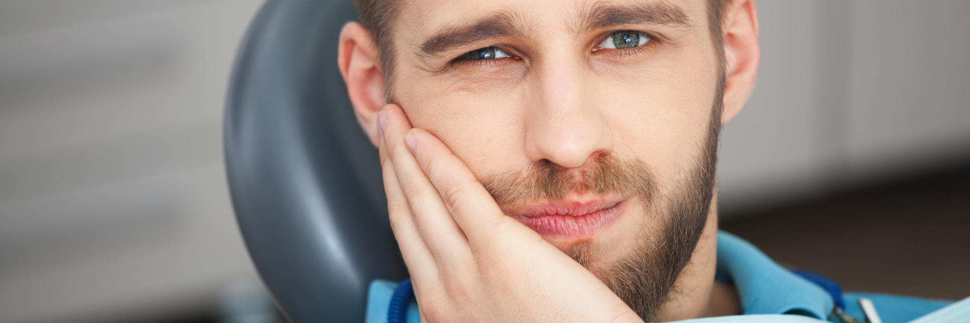 Young man with dental pain before dental consultation.