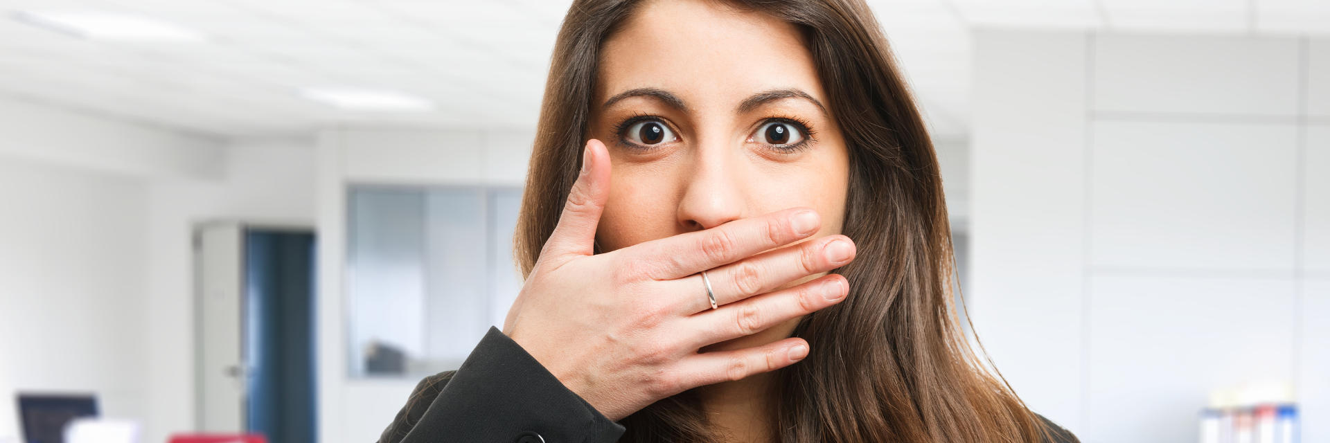 Concerned young woman covering her mouth due to bad breath.