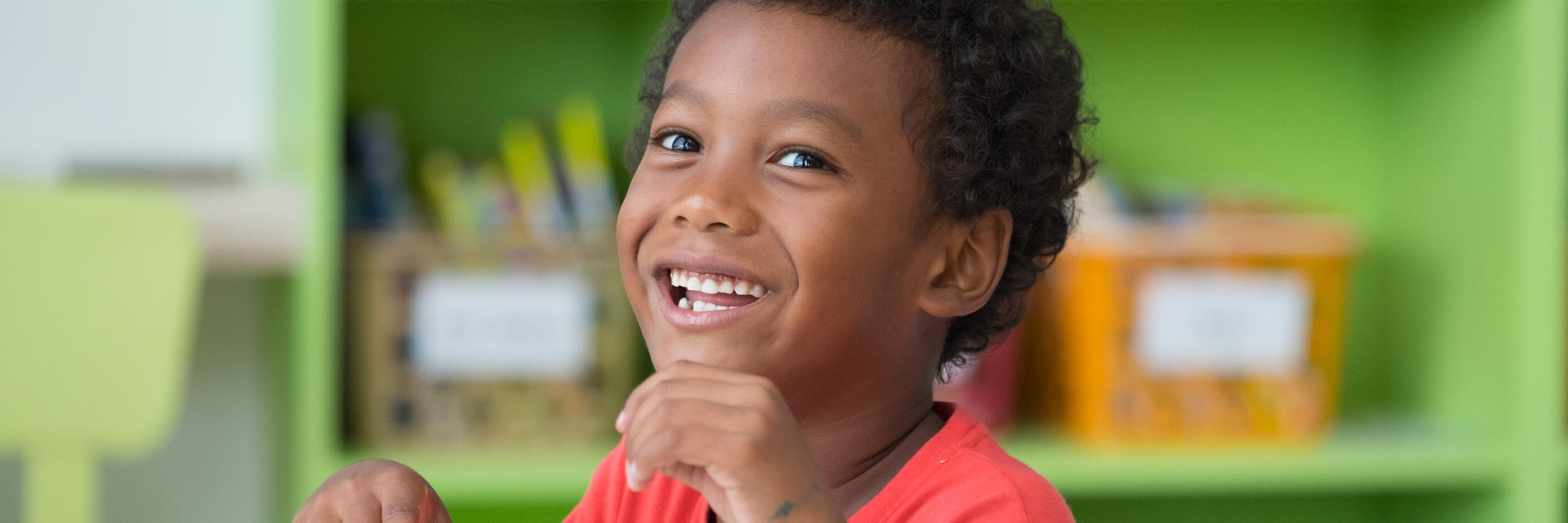 Happy Afro-American little boy showing his teeth in a smile.