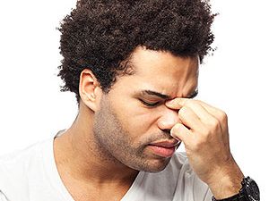 Afro-American man suffering from sinus pain.