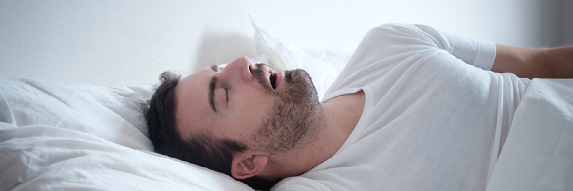 Snoring man sleeping on his back with mouth open.