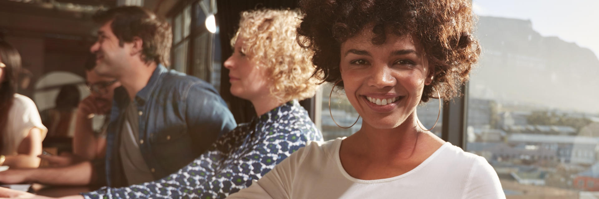 Cheerful Afro-American woman with a perfect smile socializing with friends.