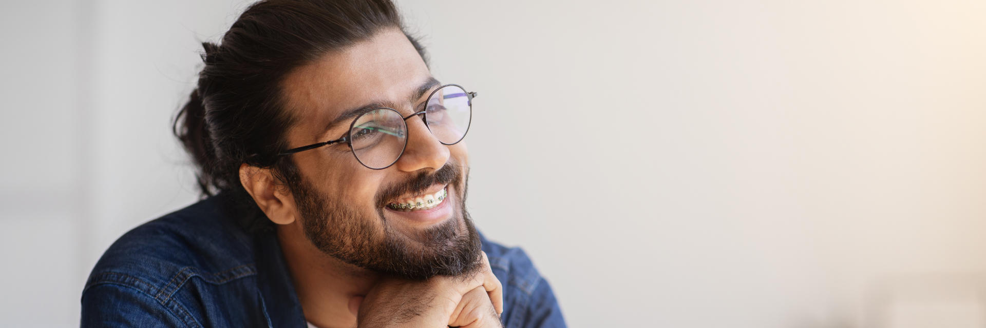 Smiling adult man wearing orthodontic braces.