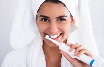 smiling woman brushes teeth